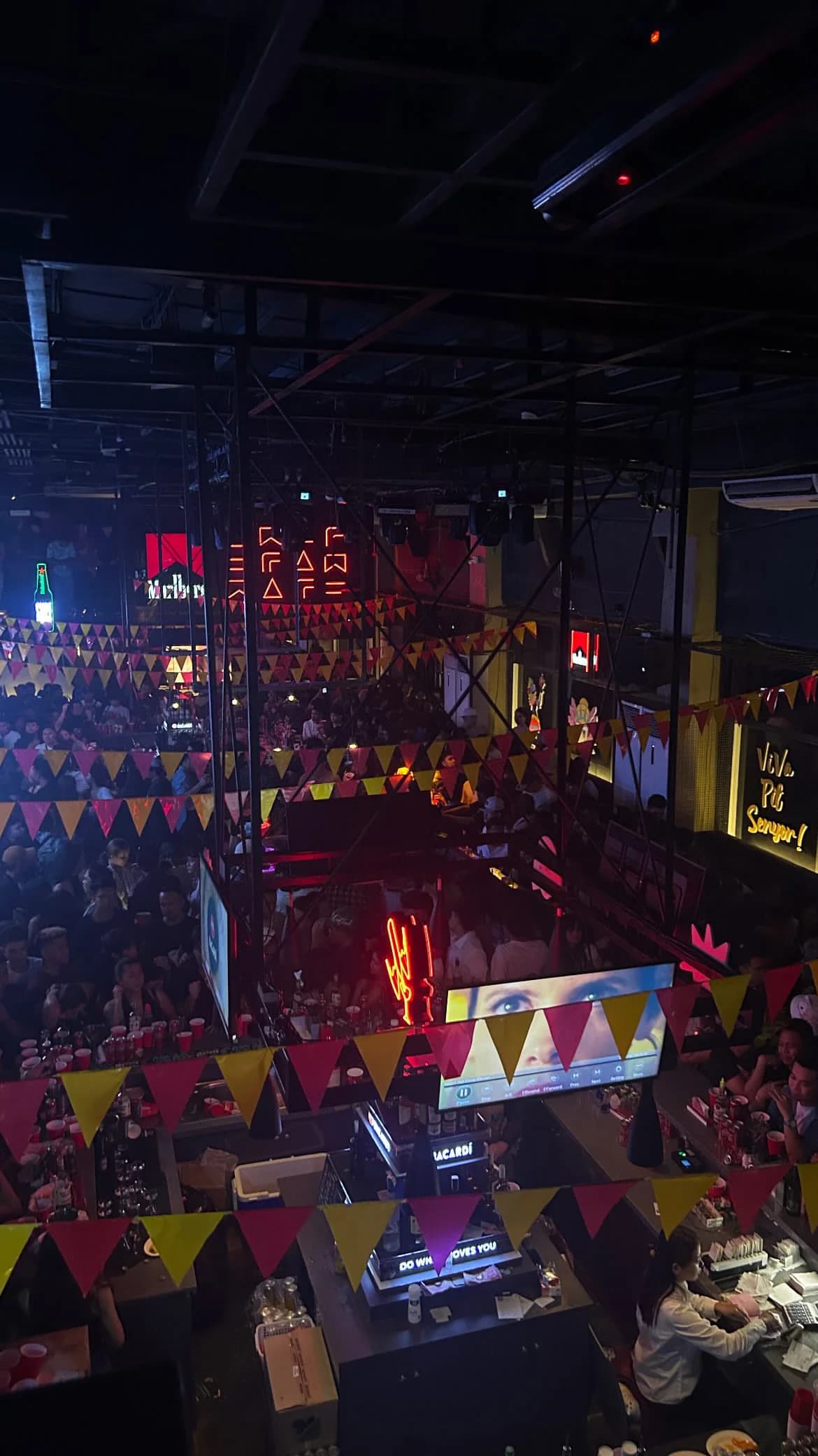 A view across a colorful indoor event space with attendees below.