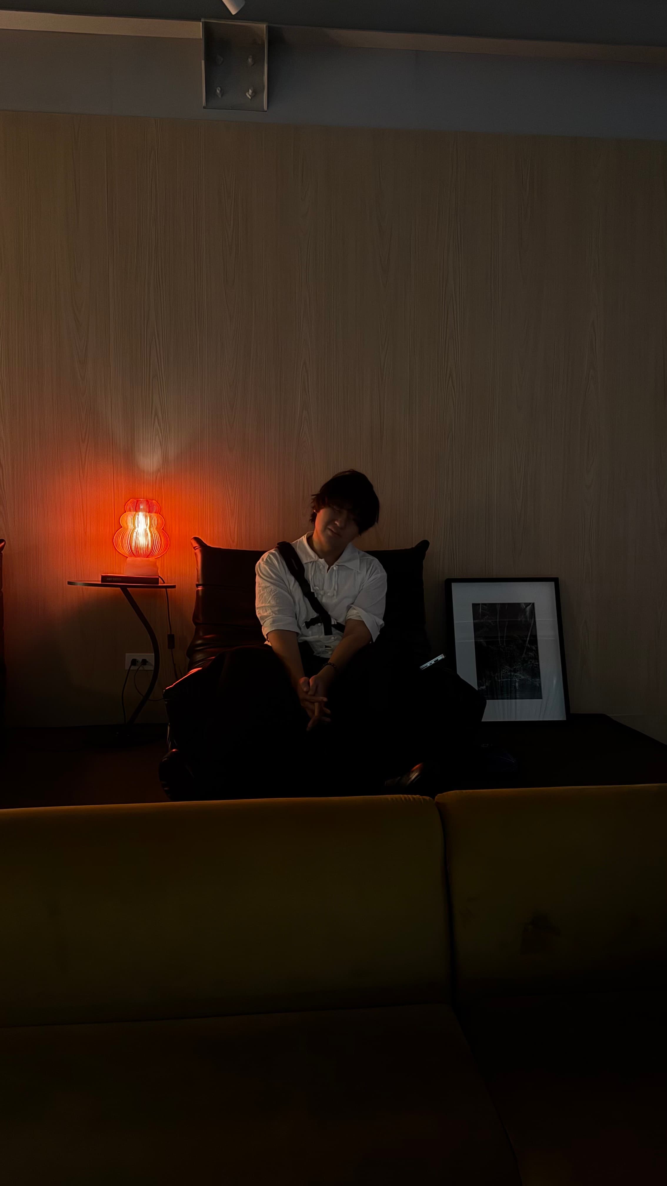 Nino Amor seated beside a warm lamp