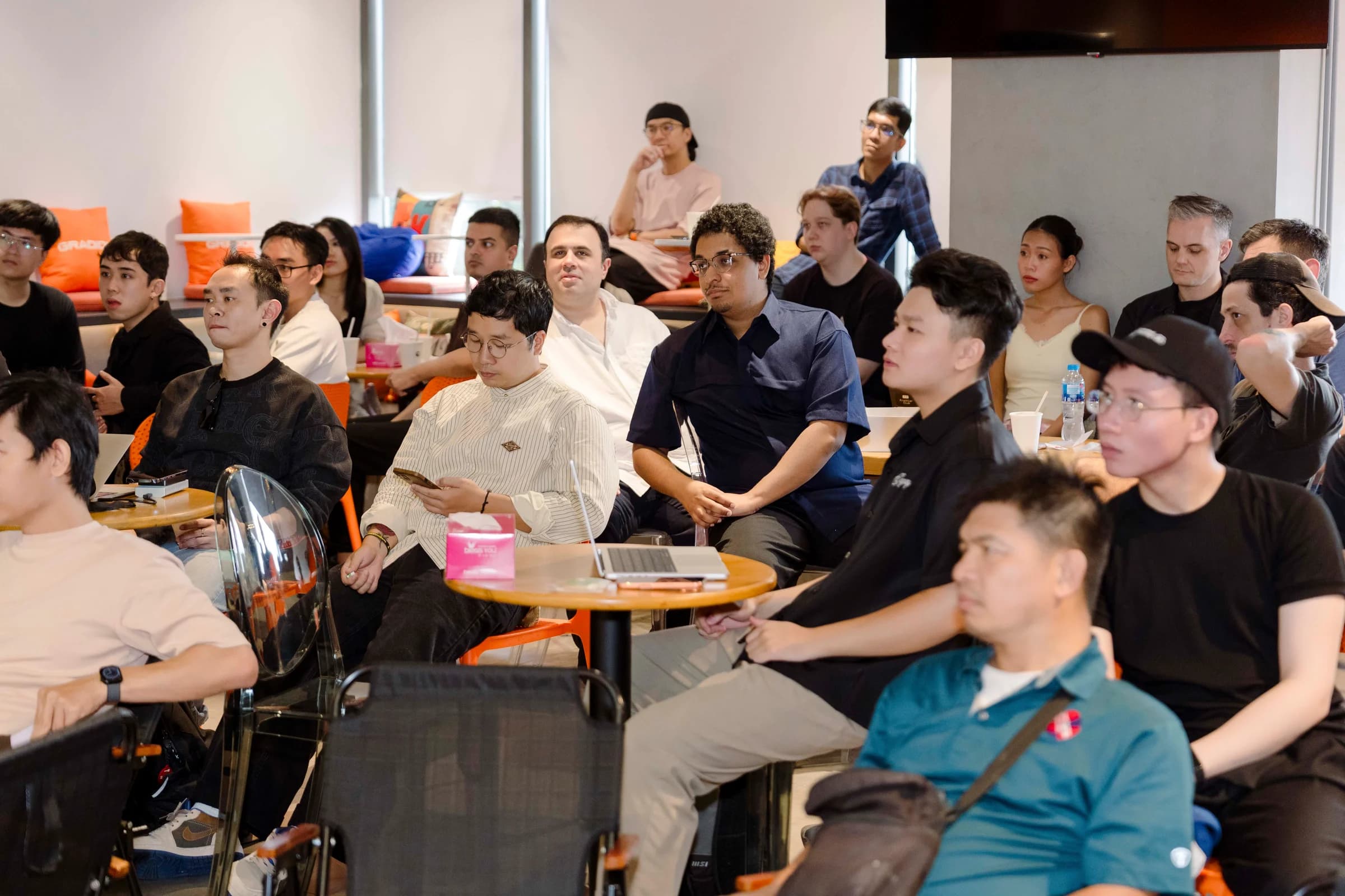 A wide view of attendees seated around tables, listening to the presentation in the Vietnam event space.
